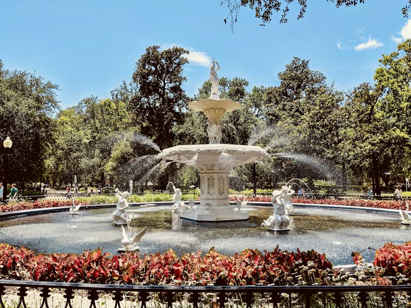 The white fountain in Forsyth Park surrounded by red flowers